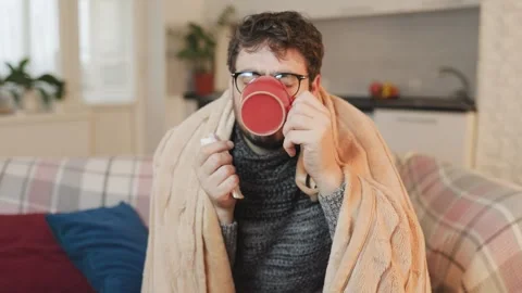 Medicinal Comfort A Guy Battling the Flu in a Cold Living Room Stock Footage 326046612