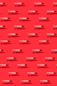 Medicinal pattern of flying syringes with red blood or vaccine. Stockfoto's