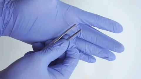 Medicine and Surgery theme: doctor's hand in a blue glove holding tweezers Stock Footage 322633370