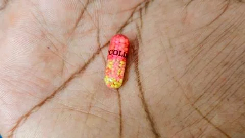 Medicine capsule on hand representing cold and illness concept Photos
