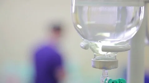 Medicine. close-up of a dropper. in the defocus of two doctors in the operating Video stock 77406150
