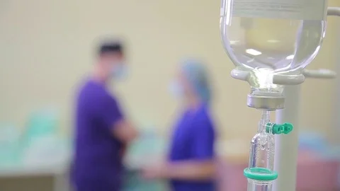 Medicine. close-up of a dropper. in the defocus of two doctors in the operating Stock Footage 77406238