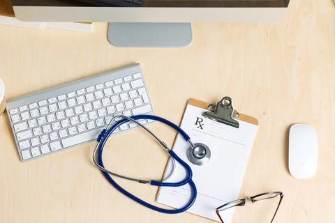 Medicine doctor's working table view from top. Monitor, keyboard, mouse, cl.. Stock Photos