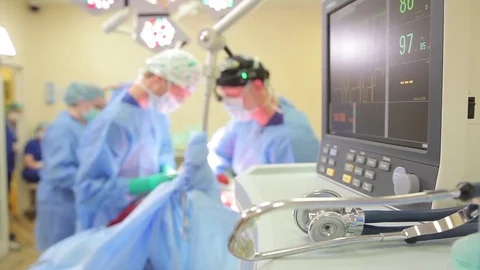Medicine. several surgeons perform the operation. heart rate monitor. by foregro Stock Footage 77450806