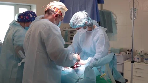 Medicine. two surgeons surgery in the operating room . bent over the patient Stock Footage 70810095