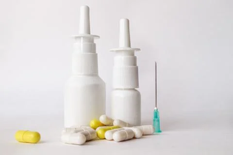 Medicines, drops in plastic bottles, tablets on a white background Stock Photos
