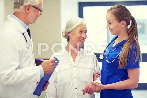Medics and senior patient woman at hospital Stock Photos