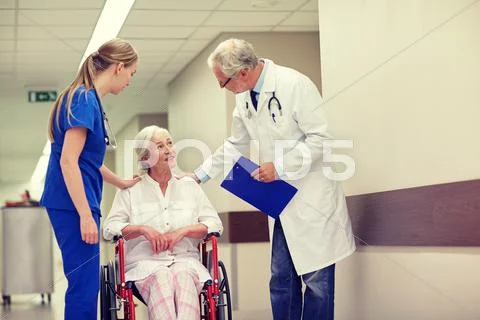 Medics and senior woman in wheelchair at hospital Stock Photos