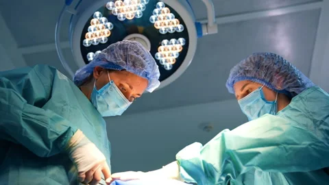 Medics performing surgery under the round lamp. Stock Footage 300890653