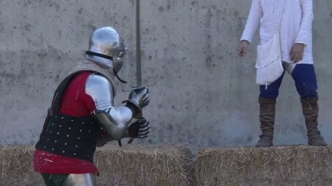 Medieval art of fighting. Two men dressing metal armor fight a sword-fired duel. Video stock 76240149