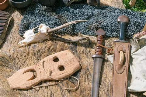 Medieval artifacts display with sword and wooden mask on fur and chainmail Stock Photos