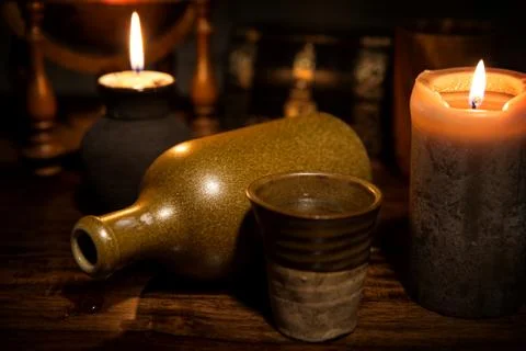 Medieval background with a old bottle, a mug and candles 스톡 사진