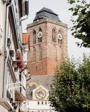 Medieval bell tower with a clock on the tower, against the background of the Stock Photos