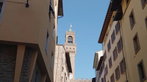 Medieval Bell Tower Framed by Historic Narrow Street and Traditional Buildi.. Vídeo Stock 340748377