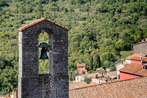 Medieval bell tower on red roofs of Roccalbegna, Grosseto, Italy Stock Photos