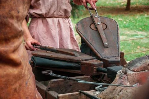 Medieval blacksmith using pair of bellows to light fire Stock Photos