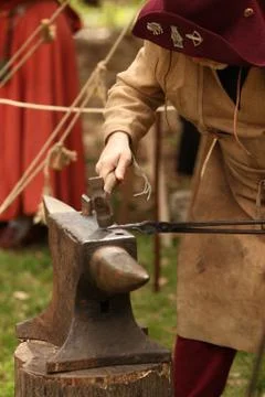 Medieval blacksmith working over an anvil Foto stock