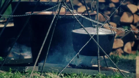 Medieval camping. Steaming pot above campfire Stock Footage 86557830