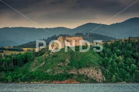 Medieval Castle on the mountain by the lake. Stock Photos