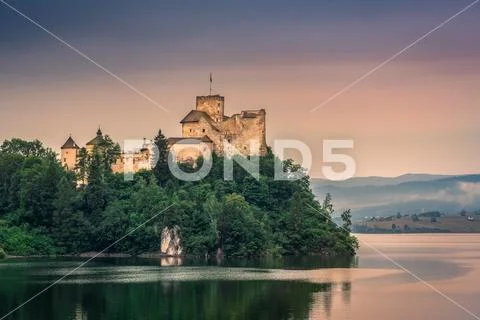 Medieval Castle on the mountain by the lake. Stock Photos