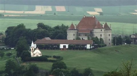 Medieval castle surrounded by much vegetation moved by the wind of summer Stock Footage 61782148