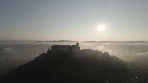 Medieval castle on top of a hill surrounded by mist at sunrise Stock Footage 212439932