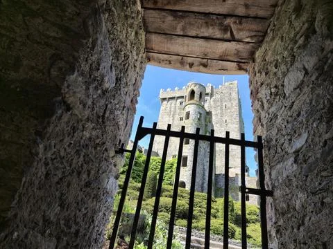 Medieval castle viewed through stone window and iron gate Photos