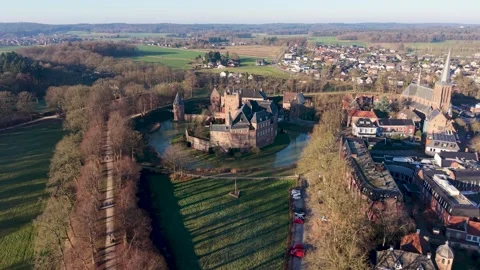 A medieval castle with a wide moat stands beside a tall steepled church Video stock 326701853