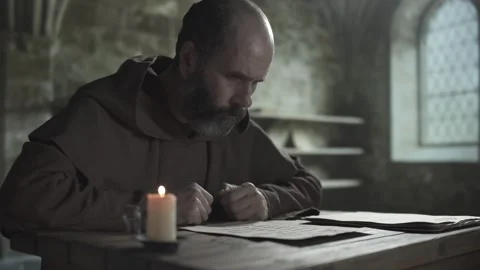 Medieval copyist examining parchment sheet and laying it on pile of manuscripts Video stock 337649277
