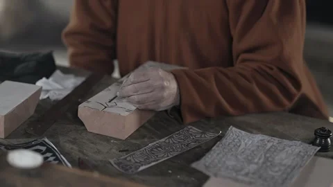 Medieval craftsman hand paints pattern onto textile printing block #3 Stock Footage 320250863