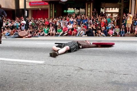Medieval fighter plays dead on street in dragon con parade Stock Photos