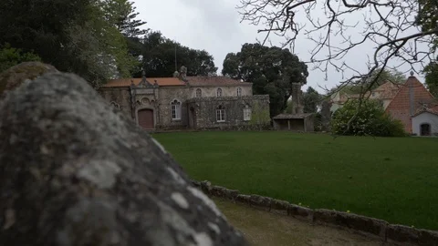 Medieval House With Big Flat Grass Yard Seen From Behind  of Rocks Slow Motion Video stock 111532215