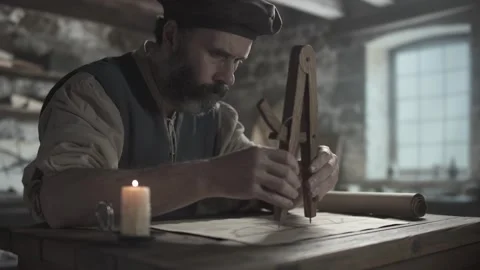 A medieval inventor checking distances on a blueprint with a wooden compass Stock Footage 340079671