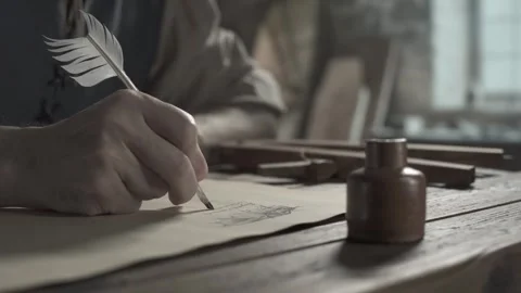 Medieval inventor writing notes below a wing sketch on a desk 库存影片 340502572