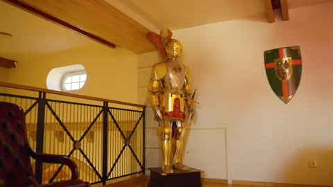 Medieval knight armor gleaming, positioned within opulent interior corner Video stock 306423281