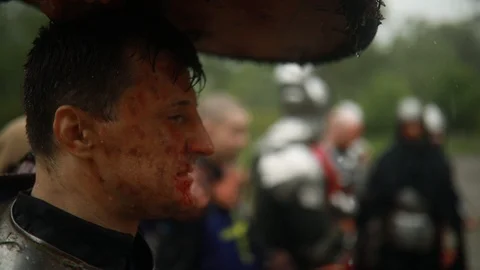 Medieval knight in armor hides from the rain under his shield. Stock Footage 109490142