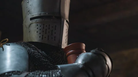 Medieval Knight in Full Armor Drinking from Clay Mug Close up with chainmail Vidéo 347081051
