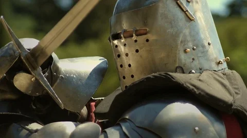 Medieval knight with metal plate armor launching sword attack Stock Footage