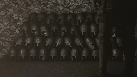 A Medieval Knight Standing in Front of a Pile of Helmets Stock Footage 107115155