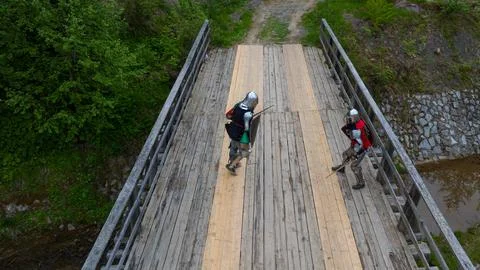Medieval knights in full armor engage in a fierce battle on a wooden bridge Stock Photos