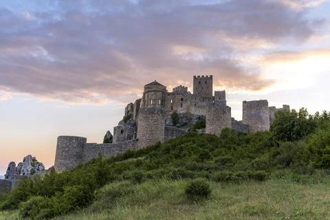 Medieval Loarre Castle beneath dramatic sunset clouds in Spain Stock Photos