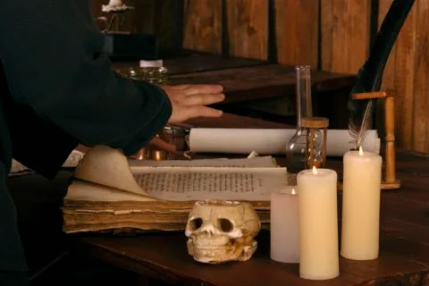 The medieval mage leaned on a spell book. Part of the body.Witchcraft Stock Photos