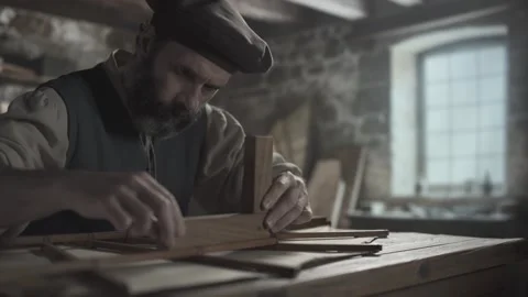Medieval master testing angles of an ornithopter wing frame with a wooden square Vídeo Stock 339232714
