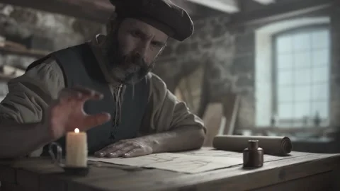 Medieval master warming a hand over a burning candle flame inside a workshop Stock-Footage 340502631