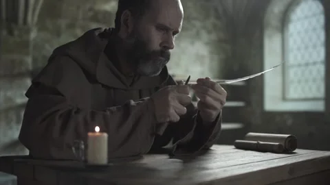 Medieval monk with a penknife making a scoop cut on a quill shaft, medium shot Video stock 337649230