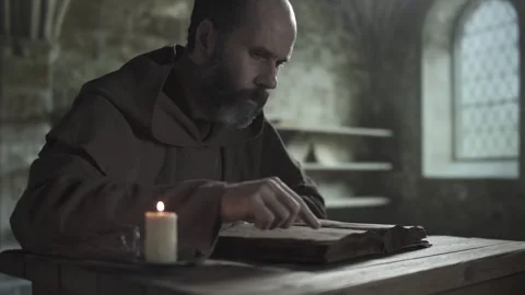 Medieval monk reading an open manuscript book, guiding finger, medium shot 스톡 동영상 339631220