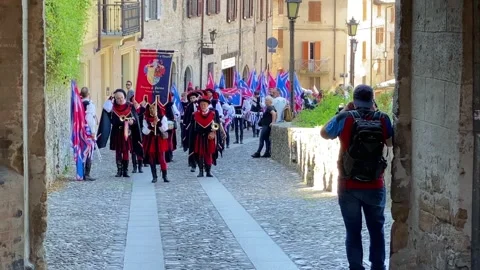 Medieval parade advancing through historic street during reenactment in Stock Footage 337725573