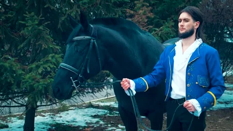 Medieval prince man hold black horse by reins. Guy strong sexy king Stock Footage 307679111