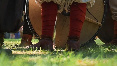 Medieval reenactors gather in a grassy field, preparing for the upcoming battle. Stockbeeldmateriaal 345030892