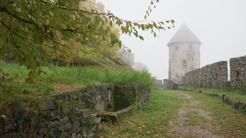 Medieval round tower and stone walls in thick fog at autumn fortress Stock Footage 325873508